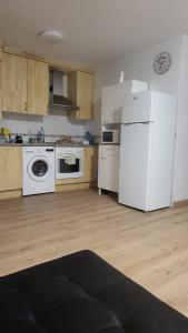 a kitchen with white appliances and a white refrigerator at Fonte Vilar in Padrón