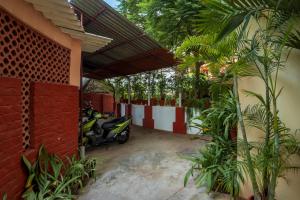 ein Roller, der in einem Innenhof neben einem Gebäude geparkt ist in der Unterkunft Sacar Guest House in Puducherry