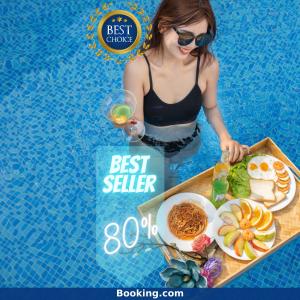 a woman sitting in a pool with a tray of food at Royal Family Hotel in Danang