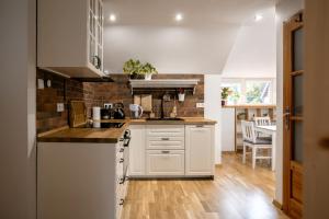 a kitchen with white cabinets and a brick wall at Pokoje z Widokiem in Bardo