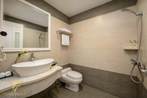 W łazience znajduje się umywalka, toaleta i lustro. w obiekcie Toàn Thắng Hotel - 421 Ngô Gia Tự, Long Biên - by Bay Luxury w mieście Trương Lâm