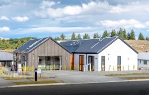 un grande edificio bianco con tetto nero di 33 Star Apartment a Lake Tekapo