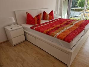 a bedroom with a large bed with red pillows at Ferienwohnung Rosenblüte in Neustadt an der Weinstraße