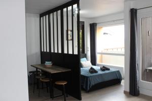 sypialnia z łóżkiem, stołem i biurkiem w obiekcie Studio centre-ville, proche des thermes w mieście Thonon-les-Bains