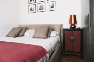 1 dormitorio con 1 cama y 1 mesa con lámpara en ComeCasa Da Chiaretta, en Milán