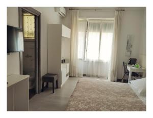 um quarto com uma cama, uma secretária e uma janela em B&B Carolina Napoli-Vomero em Nápoles