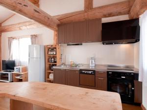 a kitchen with a wooden table and a refrigerator at Silver Birch in Niseko