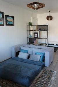 una sala de estar con un sofá azul en una habitación en Studio centre-ville, proche des thermes, en Thonon-les-Bains