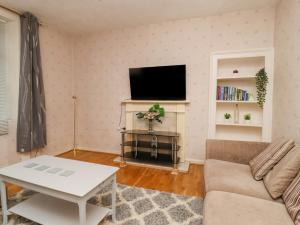 a living room with a couch and a tv at 28 Water Street in Skipton
