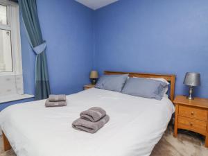 a blue bedroom with a bed with towels on it at 28 Water Street in Skipton