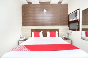 een slaapkamer met een groot bed met rode kussens bij OYO Hotel Prabhat in Zirakpur