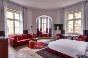un soggiorno con mobili rossi e un letto di Falkensteiner Boutique Hotel Prague a Praga