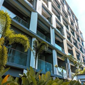 un edificio de apartamentos con ventanas azules y palmeras en Skylounge Balikpapan by Wika Realty, en Sepinggang-besar