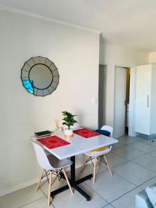 a dining room with a white table and chairs at Dmn City Apartment at Junction in Windhoek