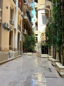 una calle vacía en un edificio con árboles y edificios en El Farida Hotel en El Cairo