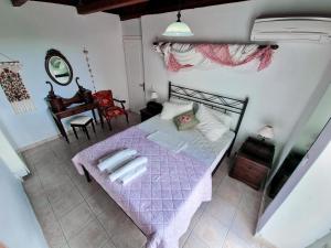 a bedroom with a bed with a purple comforter at Forestata Village in Lixouri