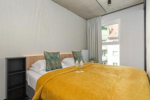ein Schlafzimmer mit einem Bett mit einer gelben Decke in der Unterkunft GREEN PORT Apartament Lwowska with SWIMMING POOL Kołobrzeg by Renters in Kołobrzeg