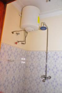 La salle de bains est pourvue d'une douche et d'une lumière au plafond. dans l'établissement Namulanda Motel, à Entebbe