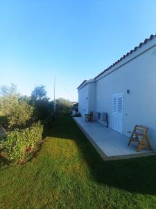 a white building with a patio and a picnic table at Sea & Country Rooms in Golfo Aranci