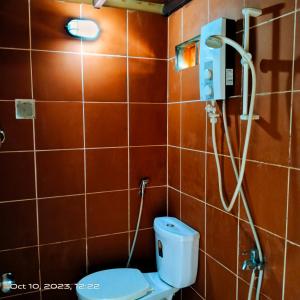 een badkamer met een toilet en een douche bij The Mango Tree Guesthouse in Kampot