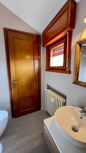 een badkamer met een wastafel en een houten deur bij La Mansardina in Parma +9 foto's