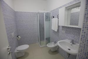 a bathroom with a toilet a sink and a shower at Residence Le Stelle in Campolungo
