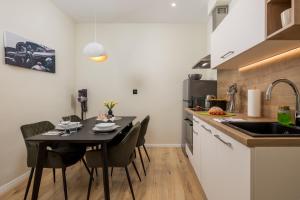 a kitchen with a table and chairs and a sink at Cosy&Lux on main square, Korzo Rijeka in Rijeka