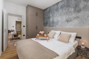 a bedroom with a large bed with a table at Cosy&Lux on main square, Korzo Rijeka in Rijeka