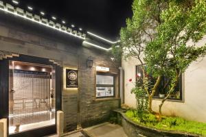 a building with a tree in front of it at Yangzhou Aihehua Boutique Homestay in Yangzhou