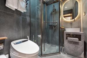 a bathroom with a shower and a toilet and a sink at Yangzhou Aihehua Boutique Homestay in Yangzhou