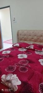 a bed with a red blanket with shells on it at Homestay CikguRose UMK in Bachok