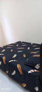 a black blanket with a cat pattern on it at Homestay CikguRose UMK in Bachok