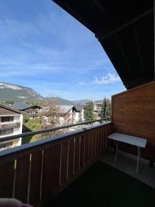 a balcony with a bench and a view of a city at Apartment „Bergblick“ in Sankt Johann in Tirol
