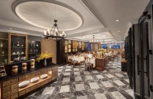 ein Restaurant mit Tischen und Stühlen und einem Kronleuchter in der Unterkunft Le Chanvre Hanoi Hotel & Spa in Hanoi