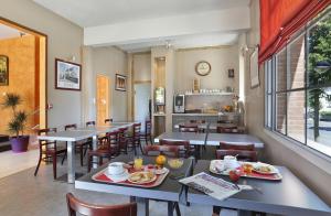 a restaurant with tables and chairs with food on them at Hôtel Les Tilleuls, Bourges in Bourges