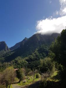 a view of a mountain range with clouds in the sky at Casinhas da Laurissilva in São Vicente