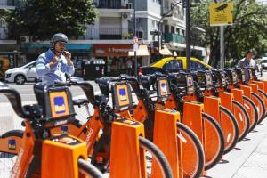 un hombre parado junto a una fila de motos naranjas en Núñez Minimal Apartment Premium en Buenos Aires