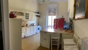 a kitchen with white cabinets and a table with chairs at Gold Genova Carbonara in Genova