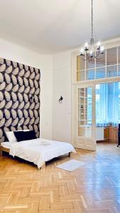 Dormitorio blanco con cama y ventana grande en Ulloi Apartment - Unique Style near Corvin, en Budapest