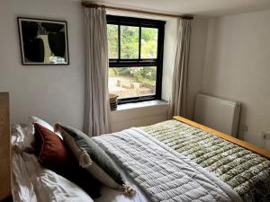 ein Schlafzimmer mit einem großen Bett und einem Fenster in der Unterkunft Bay Tree Barn in Truro