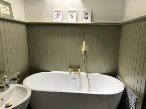 a bathroom with a large tub and a sink at Bay Tree Barn in Truro +53 photos