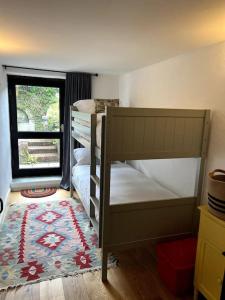 a bedroom with two bunk beds and a window at Bay Tree Barn in Truro