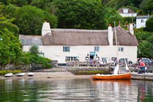 a boat on the water in front of a building at Bay Tree Barn in Truro