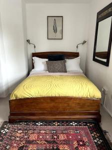 ein Schlafzimmer mit einem Bett mit gelber Bettwäsche und einem Teppich in der Unterkunft Bay Tree Barn in Truro
