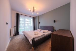 a bedroom with a bed and a large window at Grand Park Green Iulius Mall in Cluj-Napoca