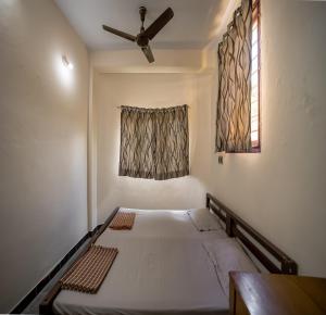 1 Schlafzimmer mit 2 Betten und einem Deckenventilator in der Unterkunft Sacar Guest House in Puducherry