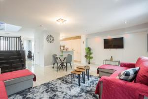 a living room with a red couch and a table at Amazing 4-Bedrooms MONTREAL in Montréal