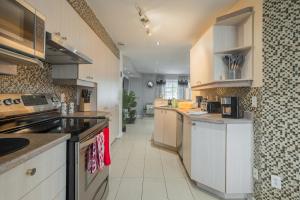 a large kitchen with white cabinets and appliances at Amazing 4-Bedrooms MONTREAL in Montréal