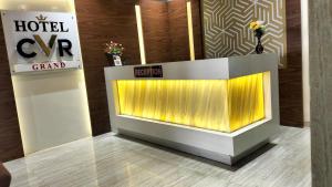 a hotel lobby with a reception desk with yellow lights at HOTEL CVR in Nānded