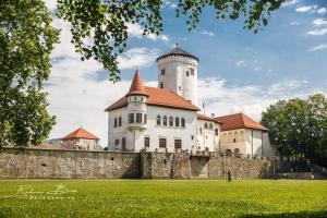 a building with a tower on top of a wall at Piano apartments - LICITY in Žilina